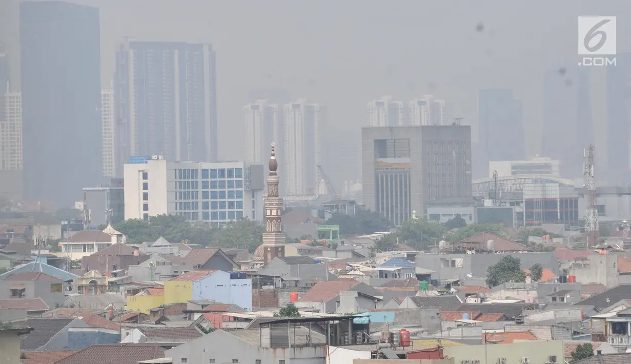 Pemandangan gedung-gedung pencakar langit dan permukiman warga saat tertutup polusi udara di Jakarta, Minggu (8/9/2019). Pada Minggu pagi kualitas udara DKI Jakarta berada pada level US Air Quality Index (AQI US) sebesar 130 atau berkategori tidak sehat bagi masyarakat sensitif. (merdeka.com/Iqbal S