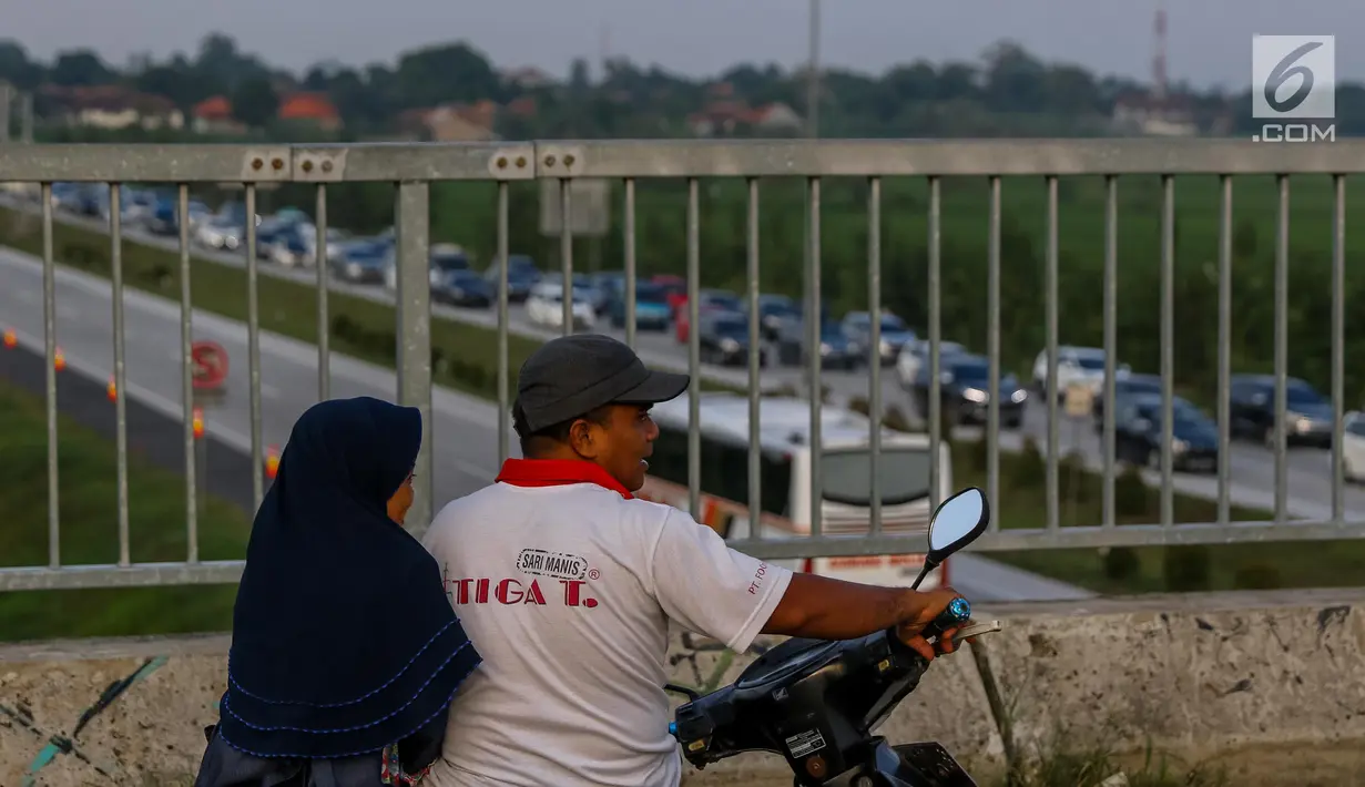 Warga berwisata sambil menyaksikan kemacetan arus lalu lintas di Gerbang Tol Utama Palimanan, Cirebon, Jawa Barat, Kamis (29/6).  (Liputan6.com/Faizal Fanani)