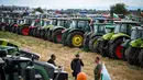 Para petani berdiri di depan traktor mereka dalam sebuah protes menentang pencabutan larangan impor biji-bijian yang berasal dari Ukraina, di Dolni Bogrov, dekat Sofia, pada tanggal 19 September 2023. (Nikolay DOYCHINOV/AFP)