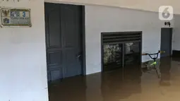Sebuah sepeda terendam saat banjir melanda kawasan Cipinang Melayu, Jakarta Timur, Jumat (19/2/2021). Banjir di kawasan tersebut akibat curah hujan yang tinggi dan meluapnya air dari Kali Sunter. (Liputan6.com/Herman Zakharia)