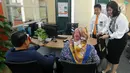 Pimpinan cabang Okky Arief Prakoso (kedua kanan) bersama staf memberikan setangkai bunga mawar dan souvenir dalam rangka HUT ke 72 BNI kepada nasabah di Kantor Cabang BNI Tebet, Jakarta (5/7). (Merdeka.com/Arie Basuki)