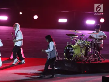 Grup Band GIGI tampil membawakan lagu saat malam penutupan Asian Games 2018 di Stadion GBK, Jakarta, Minggu (9/2). Aksi enerjik vokalis Armand Maulana mampu menghangatkan malam penutupan Asian Games 2018. (Liputan6.com/Helmi Fithriansyah)