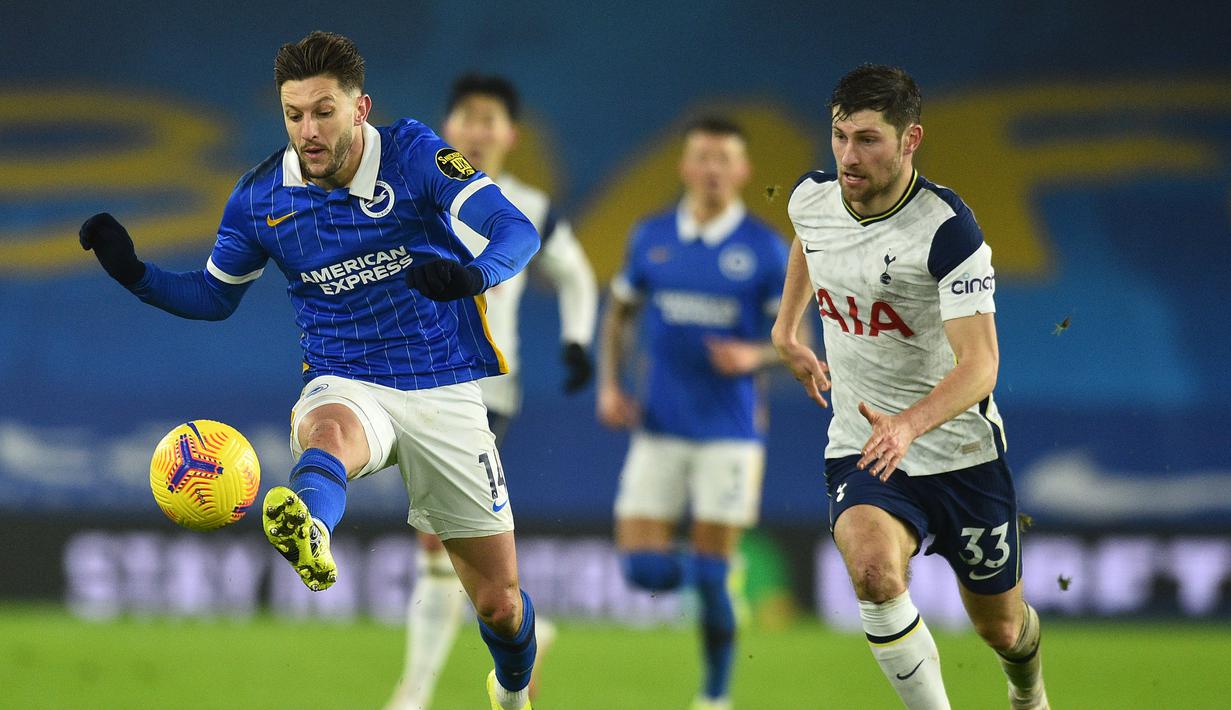 Gelandang Brighton and Hove Albion, Adam Lallana (kiri) menguasai bola dibayangi bek Tottenham Hotspur, Ben Davies dalam laga lanjutan Liga Inggris 2020/21 pekan ke-21 di American Express Community Stadium, Minggu (31/1/2021). Brighton menang 1-0 atas Tottenham. (AFP/Glyn Kirk/Pool)