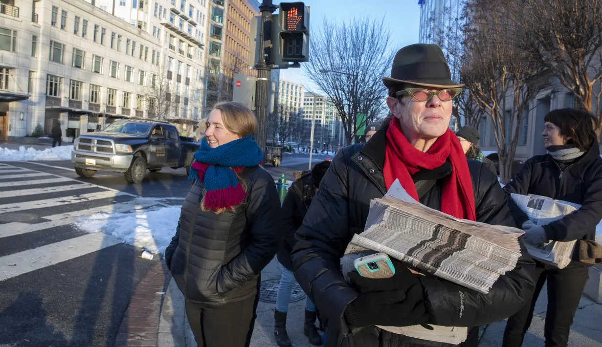 Aktivis membagikan surat kabar tiruan The Washington Post di Washington, DC, Rabu (16/1). Laporan utama berita palsu itu menceritakan Presiden Donald Trump bergegas meninggalkan Gedung Putih untuk mengakhiri krisis. (Tasos Katopodis/Getty Images/AFP)