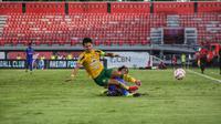 Pemain Persebaya Surabaya Bruno Moreira mendapatkan tekelan dari pemain Arema FC Ahmad Maulana di Stadion Kapten I Wayan Dipta. (Alit Binawan/Bola.com)