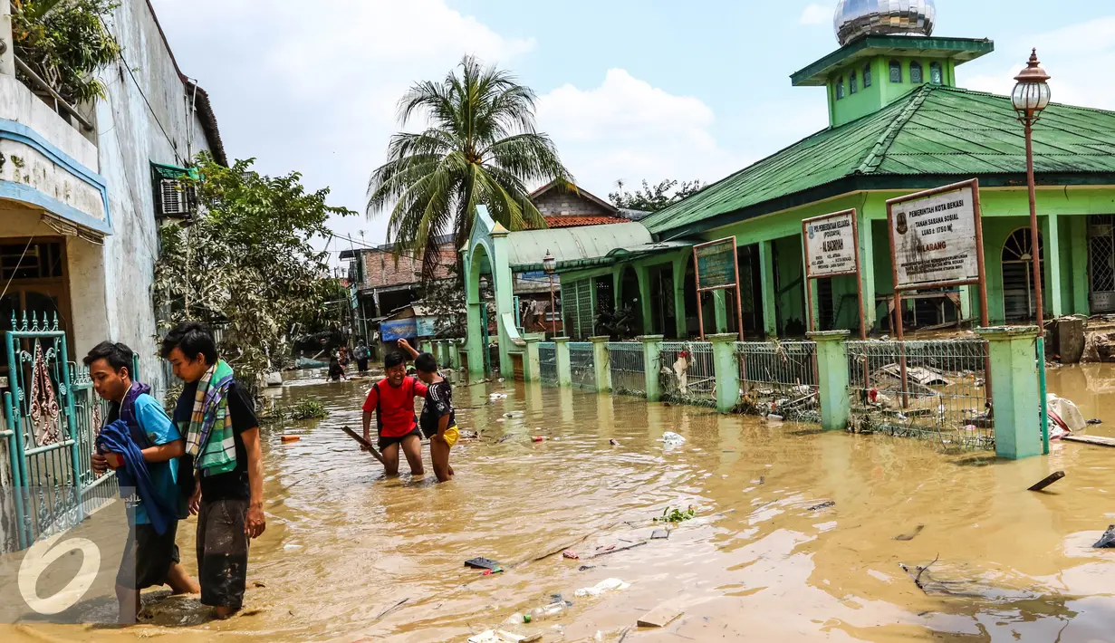 Warga melintas di kawasan banjir di Perumahan PGP Jatiasih, Bekasi, Jawa Barat, Jumat (22/4). Ketinggian air mencapai 1,5 meter dari sebelumnya ketinggian mencapai hampir 4 meter. (Liputan6.com/Fery Pradolo)