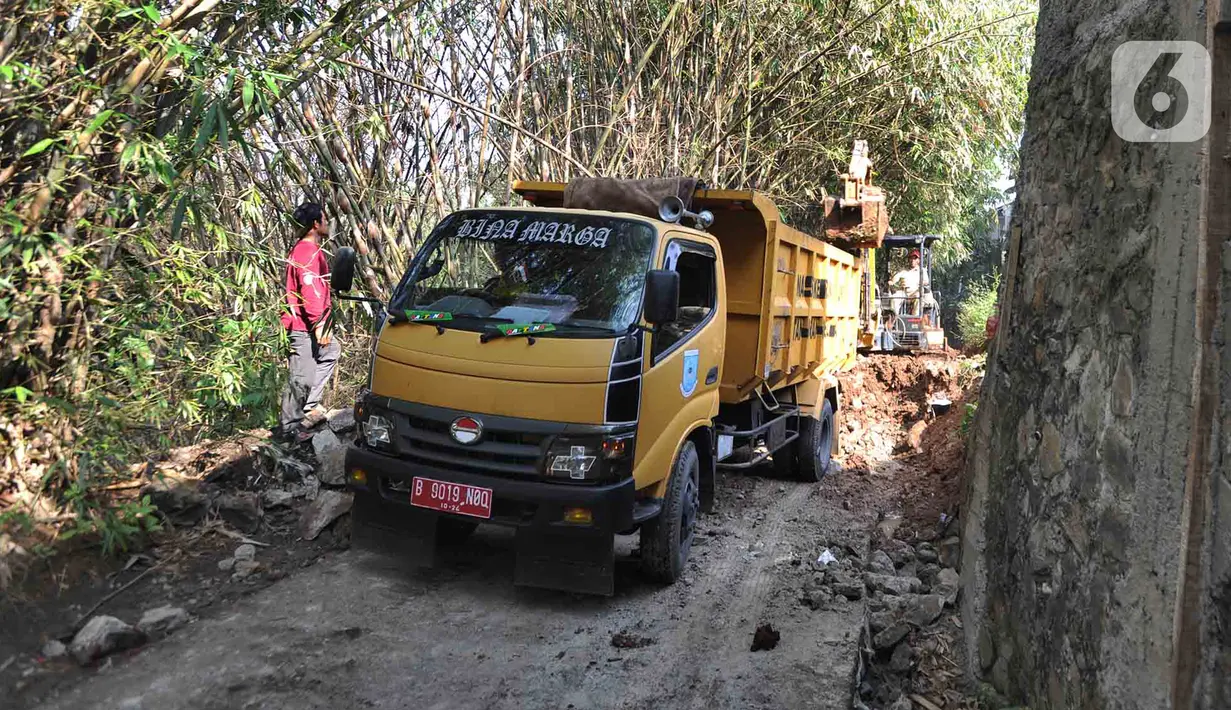 Petugas menggunakan alat berat backhoe membersihan jalan dari longsoran tanah di RT 04/RW 03, Kademangan, Keranggan, Setu, Tangerang Selatan, Banten, Selasa (3/12/2019). Longsor pada Senin sore kemarin menewaskan seorang pengendara sepeda motor yang melintas, Anggi (23). (merdeka.com/Arie Basuki)