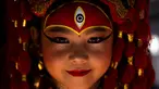 Seorang gadis muda berpakaian seperti dewi Kumari bereaksi terhadap kamera saat menunggu Kumari Puja, sebuah ritual pemujaan di Hanuman Dhoka, Basantapur Durbar Square, Kathmandu, Nepal, Rabu, 27 September 2023. (AP Photo/Niranjan Shrestha)