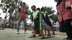 Anak-anak bermain permainan tradisional bakiak di RPTRA Melati Duri Pulo, Jakarta, Sabtu (13/10). Traditional Games Returns (TGR) mengampanyekan permainan tradisional Indonesia untuk membangkitkan eksistensinya. (Liputan6.com/Herman Zakharia)