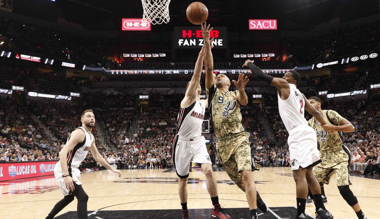 San Antonio Spurs point guard Tony Parker (9) melakukan tembakan saat dihadang para pemain Miami Heat pada lanjutan NBA di AT&T Center, Texas, Kamis (24/3/2016). San Antonio Spurs menang 112-88. (Mandatory Credit: Soobum Im-USA TODAY Sports)