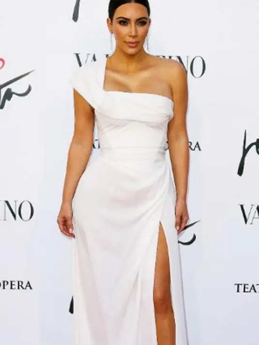 Gaun berwarna putih dan memberikan kesan anggun ini memiliki bentuk yang unik. Gaun tersebut mempunyai siluet top yang tinggi. Nampaknya, gaun tersebut kurang cocok di pakai Kim karena kekecilan. (viasplashnews/Bintang.com)