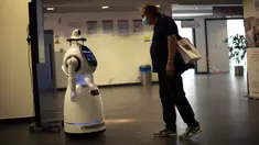 Seorang pria melihat pada robot yang dapat mendeteksi suhu dan masker di rumah sakit Universitas UZA di Antwerpen, Belgia pada 29 Mei 2020. Perusahaan Belgia, ZoraBots, menguji robot yang disebut CRUZR tersebut sebelum digunakan dalam beberapa minggu mendatang. (AP/Francisco Seco)