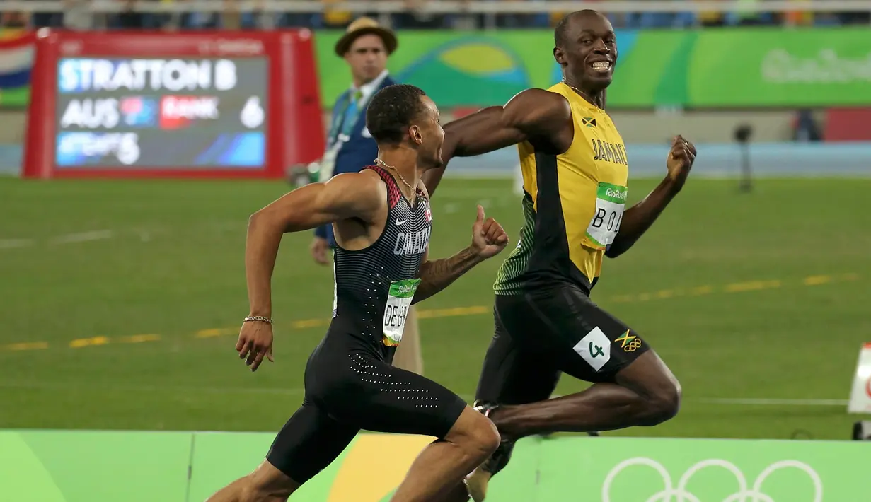 Usain Bolt tersenyum tersenyum dengan Andre de Grasse, pelari Kanada saat bersaing di semifinal lari 200 meter pria di Rio de Janeiro, Brasil (17/8). Usain Bolt meraih medali emas kedua di lari 200 meter pria. (REUTERS/Gonzalo Fuentes)