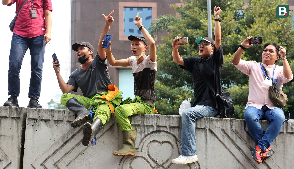 Sejumlah pekerja dan masyarakat saat menyambut Timnas Indonesia U-22 dan kontingen Indonesia untuk SEA Games 2023 saat pawai Kira87uara yang berlangsung dari Kemenpora hingga GBK, Jakarta, Jumat (19/05/2023). (Bola.com/Bagasakra Lazuardi)