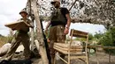 Seorang tentara Ukraina, yang sedang menghadapi separatis pro-Rusia, membawa sekotak pizza Veterano di Mariupol, 19 Juli 2018. Kedai pizza ini rutin mengantarkan pizza ke garis depan wilayah timur negeri itu yang masih bergolak. (AFP/Aleksey FILIPPOV)