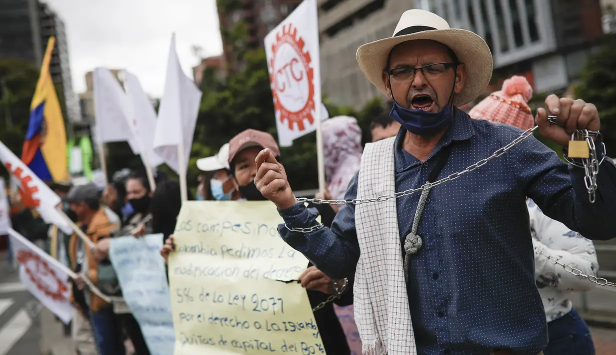 Seorang pria, memegang kunci dan rantai, ambil bagian dalam protes anti-pemerintah pada Hari Kemerdekaan Kolombia, di Bogota, Selasa (20/7/2021). Warga Kolombia turun ke jalan ketika pemerintah secara resmi mengajukan RUU reformasi pajak $3,95 miliar kepada Kongres. (AP Photo/Ivan Valencia)