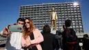 Warga berselfie dan mengabadikan patung emas raksasa PM Israel Benjamin Netanyahu di tengah-tengah Rabin Square, Tel Aviv, Selasa (6/12). (REUTERS / Baz Ratner)