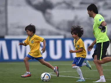 Pemain Brasil, Kaka berlatih didampingi putranya yang bernama Luca saat persiapan jelang laga penyisihan Piala Dunia 2018 melawan Argentina di Sao Paulo, Brasil, Selasa (10/11/2015). (AFP Photo/Nelson Almeida) 