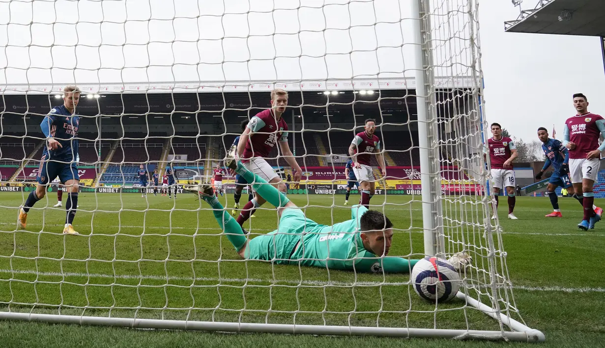 Kiper Burnley, Nick Pope gagal menghalau tendangan striker Arsenal, Pierre-Emerick Aubameyang yang berbuah gol dalam laga lanjutan Liga Inggris 2020/21 di Turf Moor, Burnley, Sabtu (6/3/2021). Burnley bermain imbang 1-1 dengan Arsenal. (AFP/Jon Super/Pool)