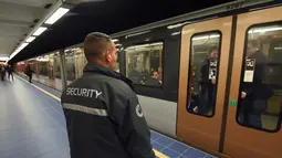 Petugas keamanan berjaga saat sebuah kereta tiba di Stasiun Metro Maelbeek di Brussels, Ibu Kota Belgia, Senin (25/4). Stasiun kereta metro tersebut akhirnya dibuka kembali setelah serangan bom 22 Maret 2016 lalu yang menewaskan 35 orang. (JOHN Thys /AFP)