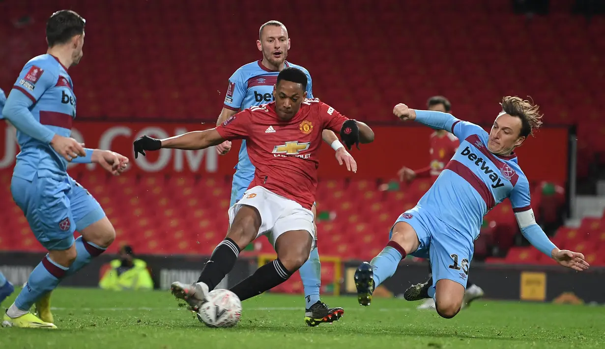 Striker Manchester United, Anthony Martial (tengah) dikurung tiga pemain West Ham United dalam laga babak kelima Piala FA 2020/21 di Old Trafford Stadium, Selasa (9/2/2021). Manchester United menang 1-0 (0-0) atas West Ham melalui extra time. (AFP/Michael Regan/Pool)