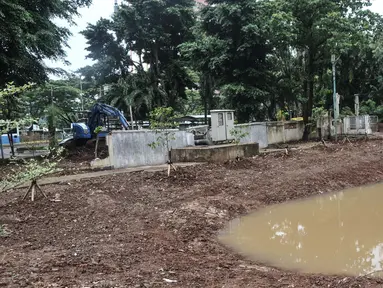 Petugas Suku Dinas Sumber Daya Air (SDA) Jakarta Pusat menggunakan kendaraan alat berat saat menyelesaikan pembuatan embung atau kolam retensi di sisi Jalan Letjen Suprapto, Cempaka Putih, Rabu (1/2/2023). Pemkot Jakarta Pusat melalui Suku Dinas Sumber Daya Air Jakpus membangun empat embung pada sejumlah lokasi di Kecamatan Cempaka Putih guna mencegah potensi banjir dan menampung air hujan 300 meter kubik dengan luas 24 meter persegi juga kedalaman 2 meter. (merdeka.com/Iqbal S Nugroho)