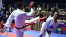 Karateka Jawa Timur, Umar Syarief (kiri) saat berlaga melawan Caesar George (Jakarta) di kelas Kumite Individu Putra +84 kg senior PON XIX di Sabuga, Bandung, Minggu (18/9). Umar menang telak 9-1 atas Caesar. (Liputan6.com/Helmi Fithriansyah)