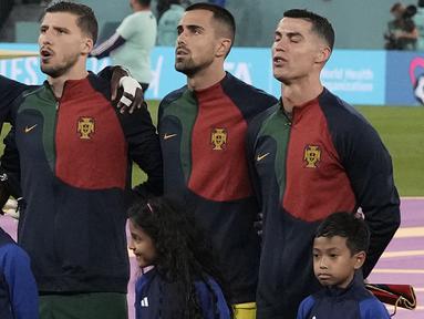 Terselip momen membanggakan bagi Indonesia saat laga Portugal menghadapi Ghana pada matchday pertama Grup H Piala Dunia 2022(24/11/2022). Dalam laga yang digelar di 974 Stadium, Doha, Qatar, bocah asal Indonesia, Ulul Albab El Ibrahim terpilih menjadi player escort atau pendamping pemain bagi bintang Portugal Cristiano Ronaldo. (AP/Hassan Ammar)