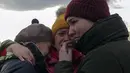 Pengungsi Ukraina menangis saat mereka bersatu kembali di perbatasan Medyka, Polandia, Sabtu, 26 Februari 2022. Dengan mobil, kereta api, dan berjalan kaki, puluhan ribu pengungsi Ukraina mencari keselamatan di negara-negara tetangga Ukraina saat invasi Rusia. (AP Photo/Visar Kryeziu)