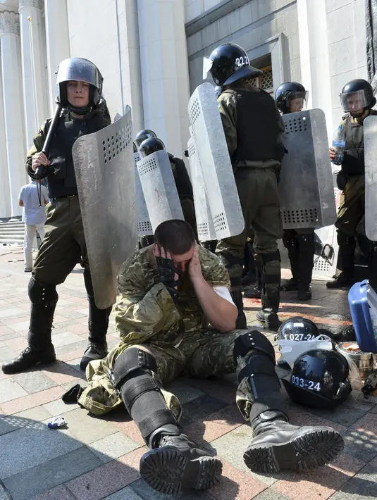 Seorang petugas terluka usai terkena ledakan di depan gedung Parlemen Ukraina di Kiev, Senin (31/8/2015). Seorang petugas tewas dan 90 orang lainnya terluka dalam aksi yang menentang perubahan UU dasar mengenai desentralisasi. (REUTERS/Stringer)