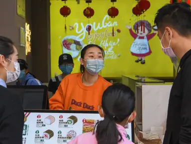 Pedagang melayani pembeli di toko makanan di Distrik Xiling, Kota Yichang, Provinsi Hubei, China, Jumat (20/3/2020). Aktivitas komersial warga Yichang berangsur normal menyusul meredanya kasus virus corona COVID-19 di China. (Xinhua/Cheng Min)