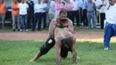 Pertandingan gulat oli ini di pimpin oleh seorang wasit. (AFP Photo/Adem Altan)