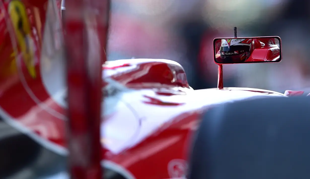 Refleksi pebalap Ferrari, Kimi Raikkonen, dari spion mobilnya saat latihan bebas pertama dalam F1 GP Abu Dhabi di Sirkuit Yas Marina, Abu Dhabi, (27/11/2015). (AFP/Andrej Isakovic)