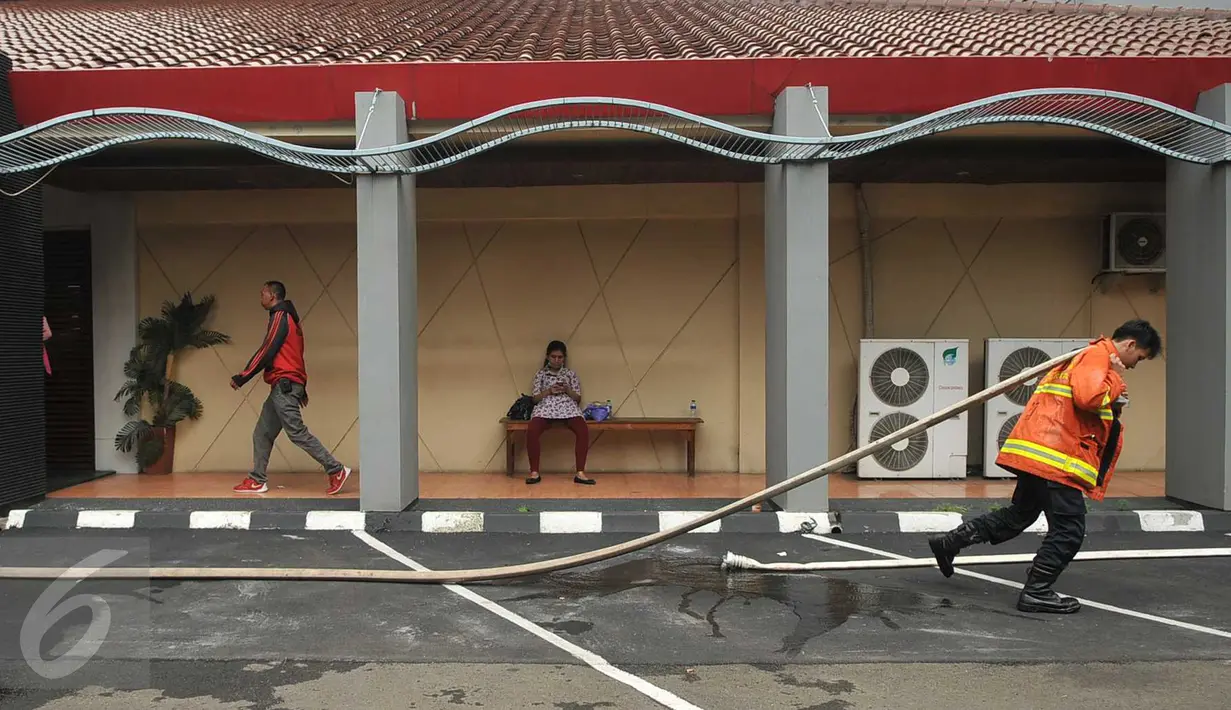 Petugas pemadam menarik selang usai kebakaran yang melanda gedung Hotel and Spa Fortune, Jakarta, Rabu (20/4/2016). Kebakaran tersebut diduga akibat korsleting dari charger handphone. (Liputan6.com/Gempur M Surya)