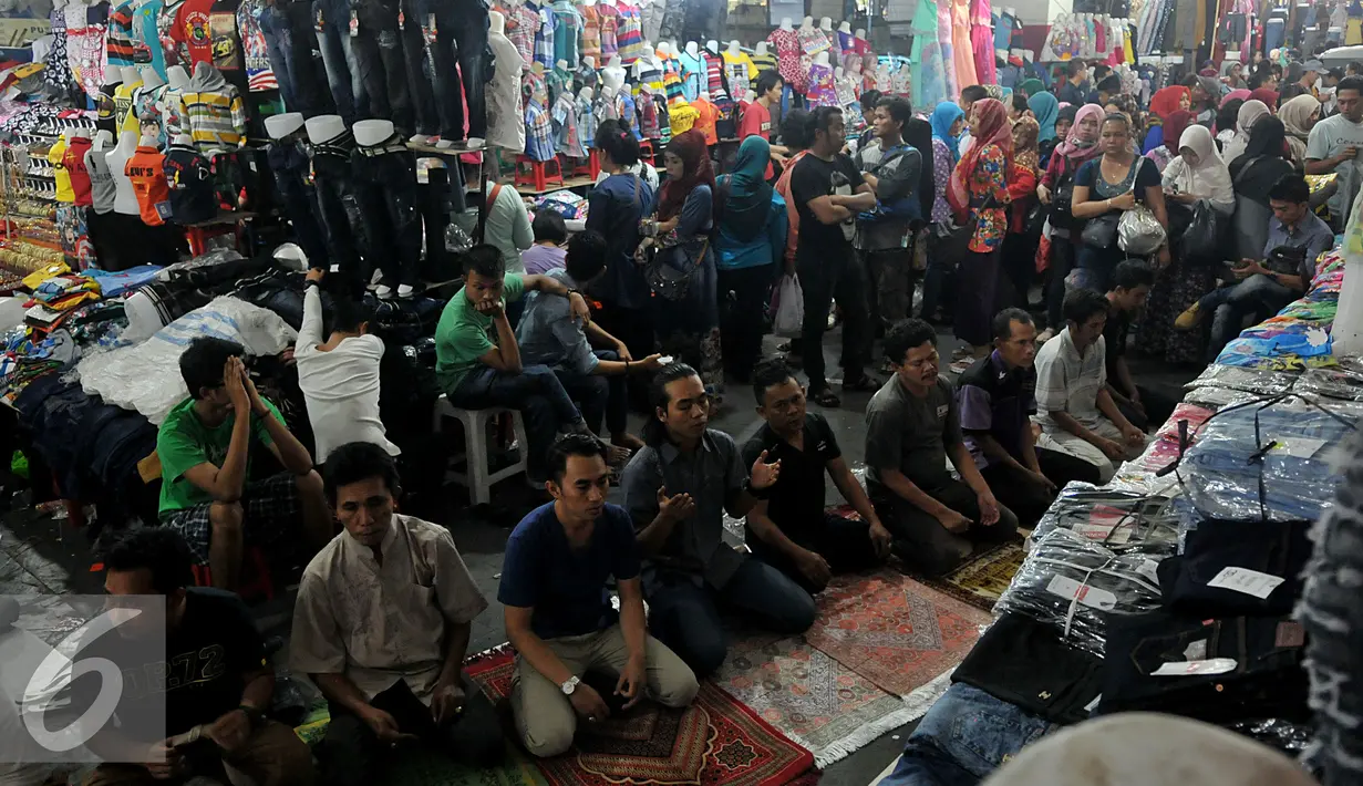 Sejumlah umat muslim berdoa usai melakukan ibadah Shalat Jumat di lorong yang menghubungkan Pasar tanabang Blok A dan B, Jakarta Pusat (26/7/215).  Saat beribadah Para pedagang  menghentikan aktifitas jual-beli. (Liputan6.com/Johan Tallo)