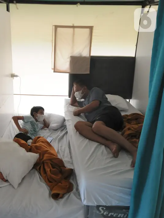 Seorang ayah dan anaknya berbincang di dalam Rumah Lawan COVID-19 (RLC) Serpong, Tangerang Selatan, Banten, Rabu (2/6/2021). RLC merawat lebih dari 60 pasien positif covid-19 yang melonjak drastis lebih dari 50 persen pasca lebaran. (merdeka.com/Arie Basuki)