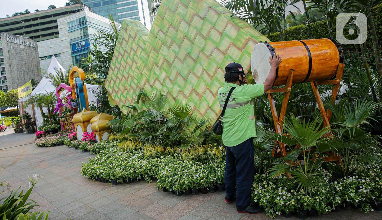 <p>Petugas menata dekorasi bertemakan Idul Fitri di kawasan Bundaran HI, Jakarta, Rabu (27/4/2022). Dekorasi berbentuk masjid, ketupat, dan bedug yang dihiasi oleh tanaman tersebut dalam rangka menyambut Idul Fitri 1443 Hijriah. (Liputan6.com/Faizal Fanani)</p>