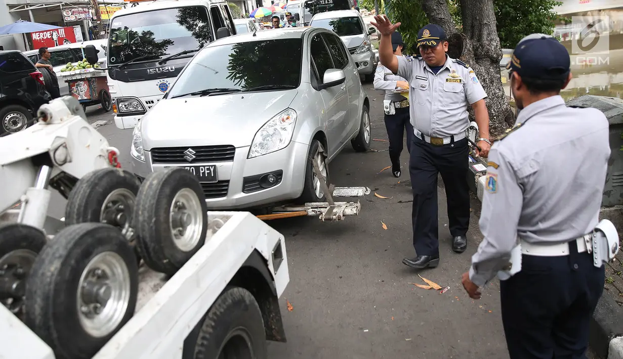 Mobil Dinas Perhubungan menderek kendaraan yang terjaring parkir liar di kawasan Pasar Baru, Jakarta, Kamis (14/12). Meskipun sering ditertibkan, namun masih banyak pengendara yang nekat parkir sembarangan. (Liputan6.com/Immanuel Antonius)