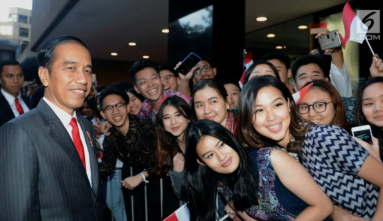Presiden Joko Widodo atau Jokowi foto bareng warga saat tiba di hotel tempatnya menginap di Sydney, Australia, Jumat (16/3). Jokowi antusias menyapa sekaligus menerima ajakan bersalaman serta berfoto bersama. (Liputan6.com/Pool/Biro Pers Setpres)