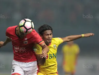 Duel pemain Persija Jakarta, Vava Yagalo (kiri) dan pemain Bhayangkara FC, Ilham Udin pada lanjutan Liga 1 2017 di Stadion Patriot Bekasi, Sabtu (12/11/2017). Bhayangkara kalah dari Persija 1-2. (Bola.com/Nicklas Hanoatubun)