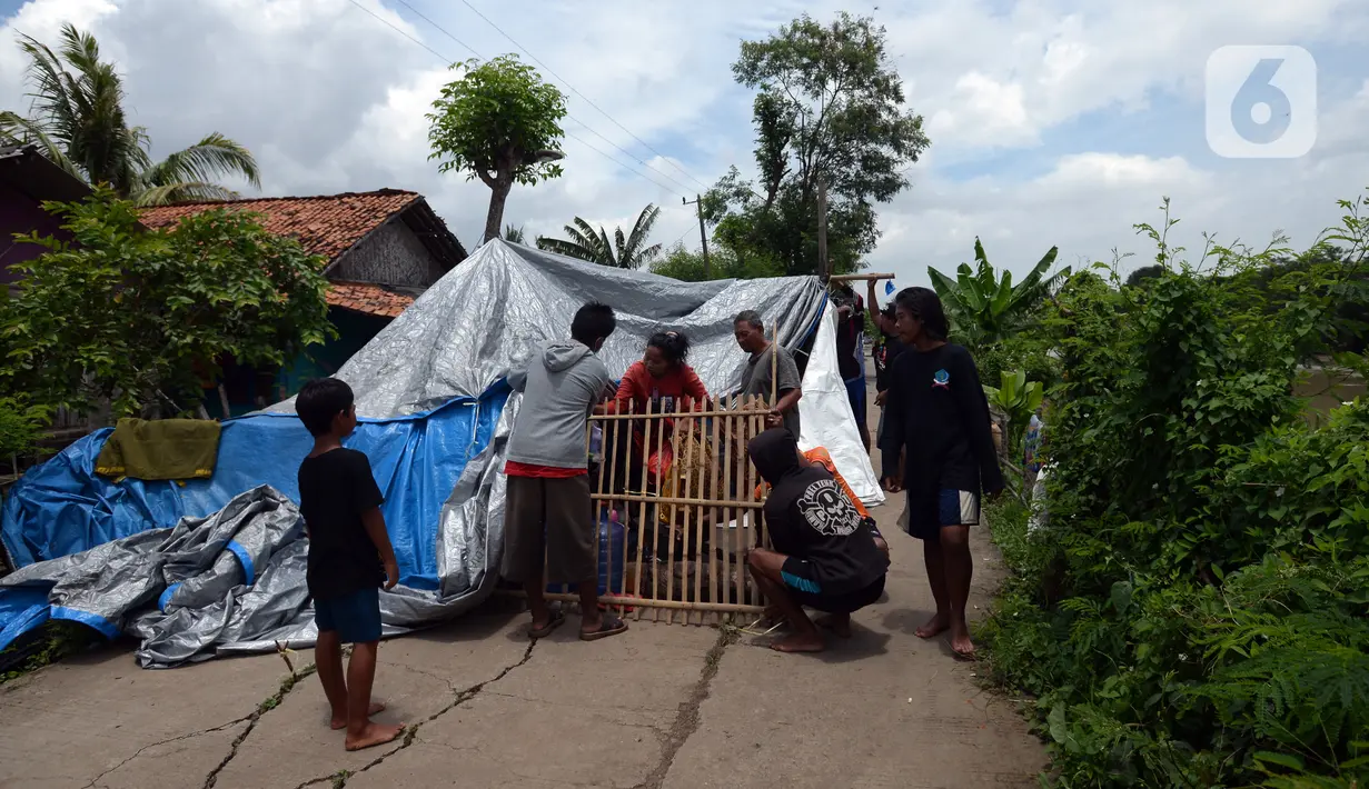 Warga membangun tenda saat banjir di Desa Sindangsari, Kabupaten Bekasi, Jawa Barat, Rabu (24/2/2021). Sebagian rumah warga masih terendam banjir yang disebabkan jebolnya tanggul Sungai Citarum dan luapan Sungai Ciherang. (merdeka.com/Imam Buhori)