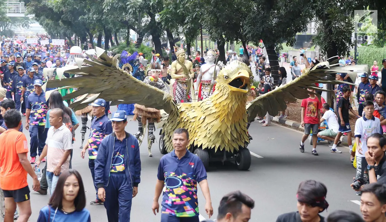 Sejumlah masyarakat mengenakan pakaian adat dan melakukan karnaval di jalan Pintu 1 Senayan, Jakarta, Minggu (24/9). Karnaval tersebut dilakukan dalam rangka HUT Gelora Bungkarno yang ke-55. (Liputan6.com/Angga Yuniar)