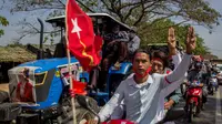 Para pengunjuk rasa dengan skuter dan petani yang mengendarai traktor dengan poster pemimpin sipil Myanmar Aung San Suu Kyi yang ditahan di bagian depan mengambil bagian dalam demonstrasi menentang kudeta militer di Thongwa, di pinggiran Yangon (12/2/2021). (AFP/STR)