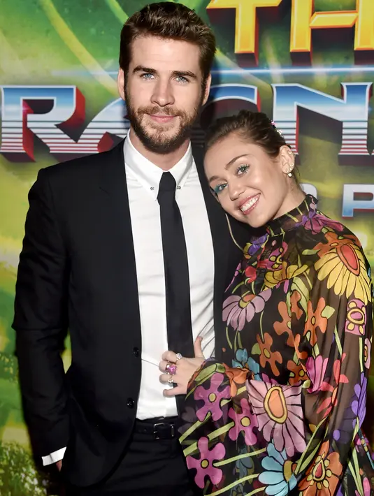 Kemesraan Miley Cyrus dan Liam Hemsworth di karpet merah premier film 'Thor: Ragnarok' di California, 10 Oktober 2017. Miley terlihat begitu manja saat meletakkan kepalanya di pundak pemain film THE HUNGER GAMES itu. (Rich Polk/Getty Images/AFP)