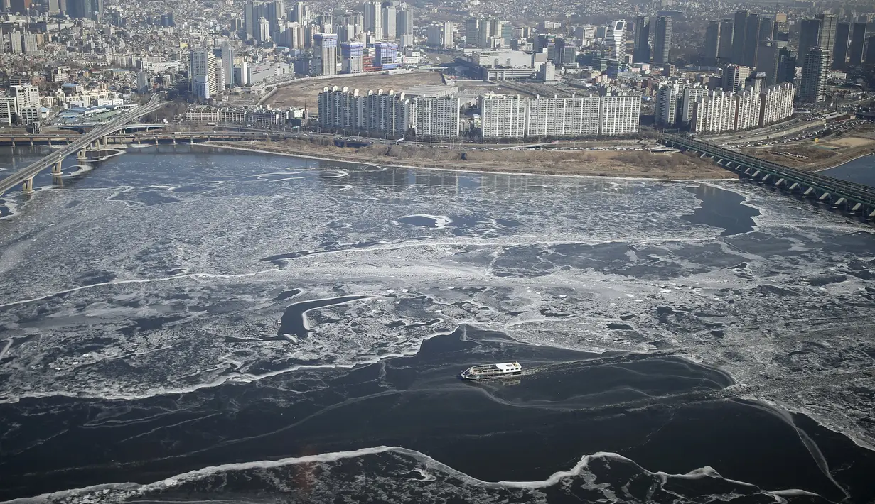 Sebuah kapal penumpang menyeberangi aliran es di Sungai Han yang membeku di Seoul, Korea Selatan, Senin (25/1). Sungai Han membeku akibat suhu di Korea yang kini mencapai minus dol derajat Celsius. (REUTERS/Kim Hong - Ji)