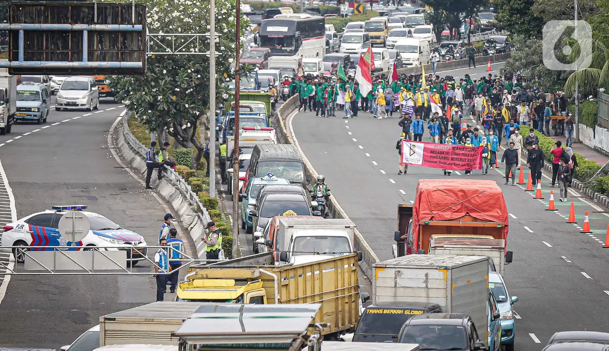 Massa mahasiswa sejumlah aliansi membentangkan spanduk saat mulai mendatangi kawasan sekitar Gedung DPR, Jakarta, Senin (11/4/2022). Ada empat tuntutan yang disuarakan dalam aksi mahasiswa, salah satunya menolak penundaan pemilu 2024 atau masa jabatan 3 periode. (Liputan6.com/Faizal Fanani)