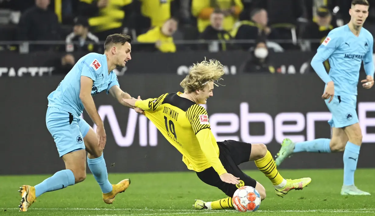 Gelandang Greuther Fuerth Paul Seguin (kiri) dan penyerang Borussia Dortmund Julian Brandt pada laga pekan ke-16 Bundesliga di Signal Iduna Park, Kamis (16/12/2021) dini hari WIB. Borussia Dortmund mampu meraih kemenangan 3-0 atas Greuther Fuerth. (Ina Fassbender/AFP)