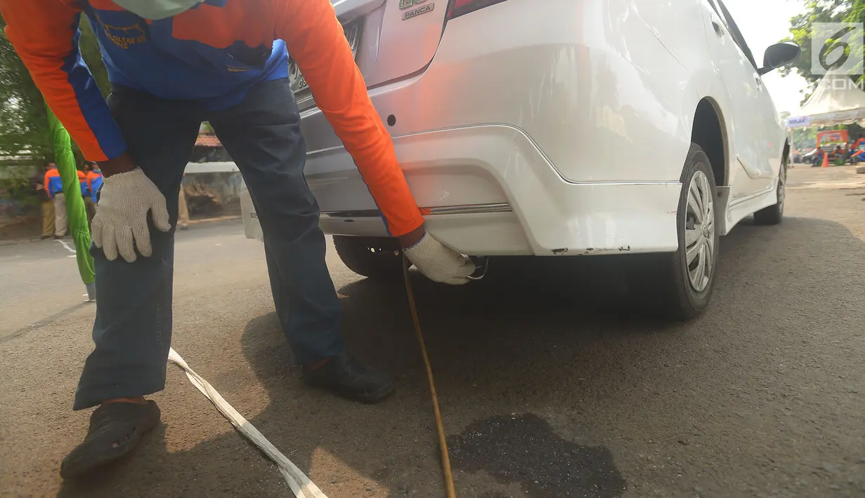 Petugas melakukan uji emisi gas buang kendaraan di Kalibata, Jakarta, Rabu (24/7). Uji emisi kendaraan di lakukan untuk kadar kualitas udara perkotaan, seiring meningkatnya volume kendaraan bermotor di kota-kota besar. (Merdeka.com/Imam Buhori)