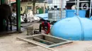Pekerja mengatur konverter biogas yang mengubah kotoran sapi menjadi gas untuk kebutuhan tumah tangga di kawasan Pancoran, Jakarta, Selasa (12/12/2023). (Liputan6.com/Herman Zakharia)
