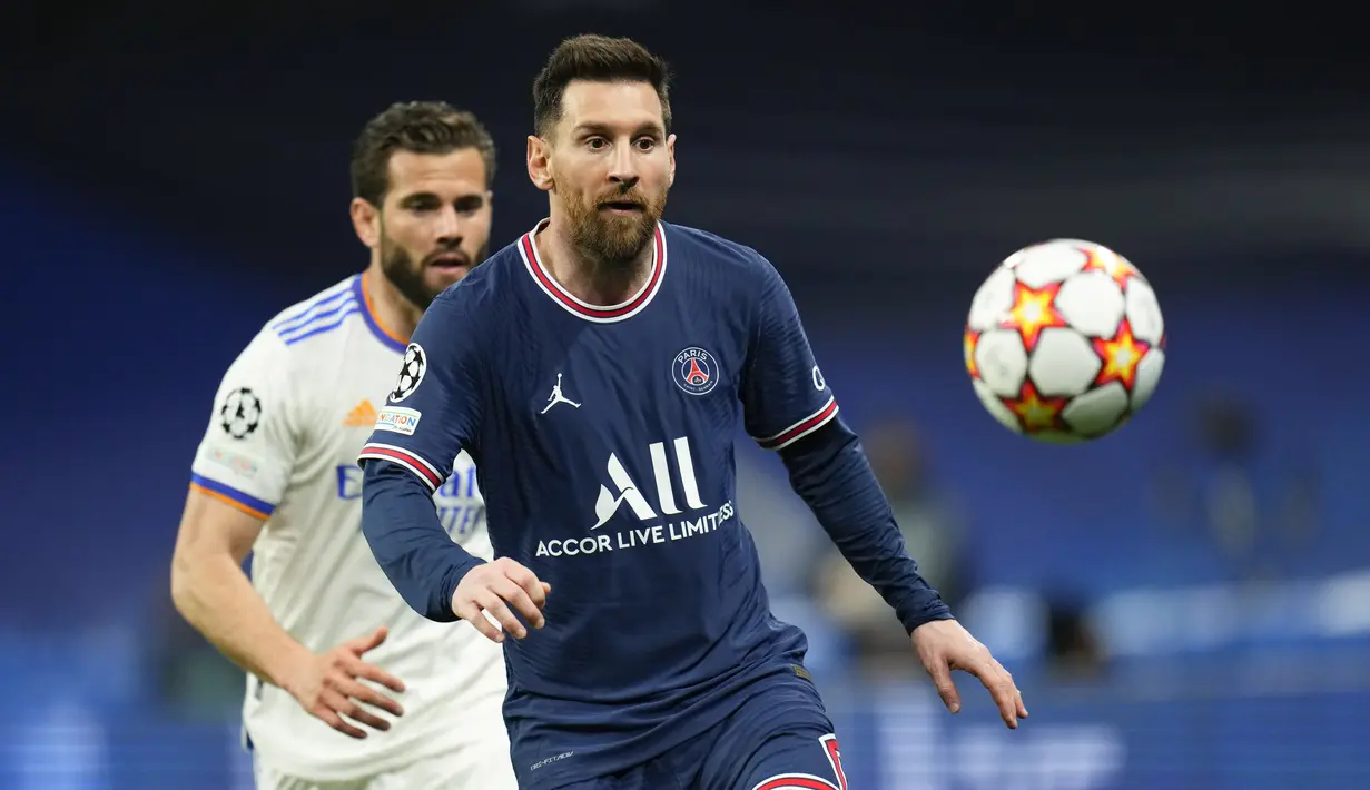 Penyerang Paris Saint-Germain (PSG) Lionel Messi berebut bola dengan bek Real Madrid Nacho pada leg kedua 16 besar Liga Champions di Santiago Bernabeu, Kamis (10/3/2022) dini hari WIB. Real Madrid secara dramatis sukses menyingkirkan PSG setelah menang 3-1. (AP Photo/Manu Fernandez)